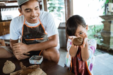 parent and kid making goods with clayの写真素材