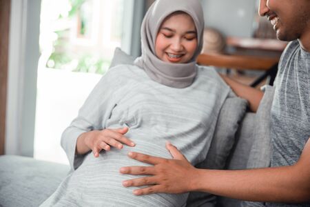 couples hand hold on pregnant bellyの写真素材