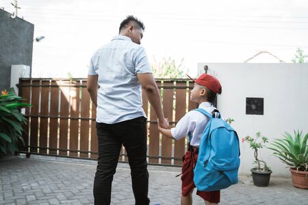 father take his elementary student son going to schoolの写真素材