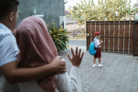 kid waving goodbye to parent before schoolの写真素材