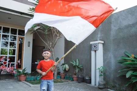 proud kid waving indonesian flag on independence dayの写真素材