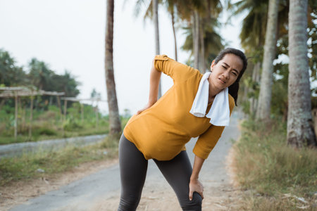 pregnant woman back pain during exercising outdoor