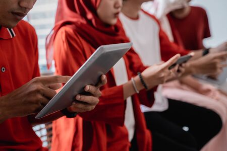 young people sitting together using their own gadgetの写真素材