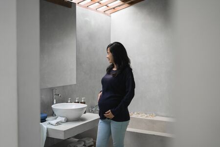 Asian young mothers see a mirror in the bathroomの写真素材