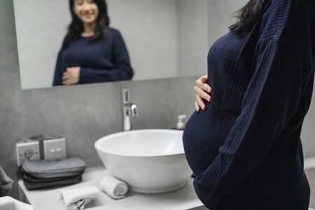 Asian young mothers see a mirror in the bathroomの写真素材