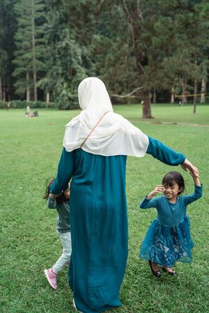 two little girls with their mothers playing togetherの写真素材