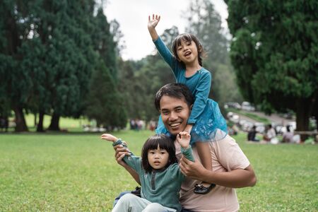 two daughters with their father enjoying a holidayの写真素材