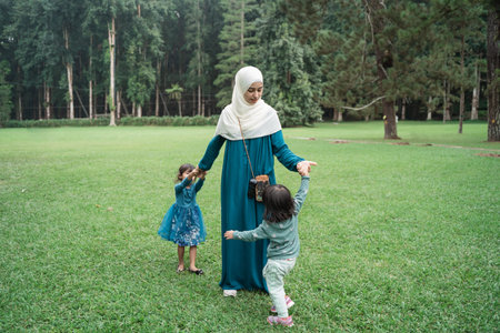 two little girls with their mothers playing togetherの写真素材
