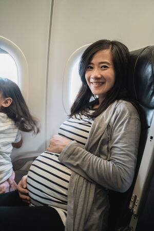 Asian pregnant women enjoy traveling by airplaneの写真素材