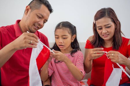 parent with daughter preparing and make their own indonesian flagの写真素材