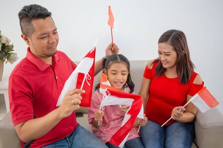 parent with daughter preparing and make their own indonesian flagの写真素材