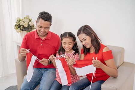 parent with daughter preparing and make their own indonesian flagの写真素材