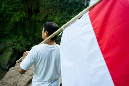 asian male with indonesian flag celebrating independence dayの写真素材