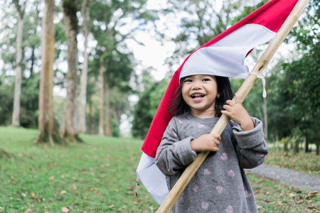 Indonesian girl holding bamboo stick with big flag
