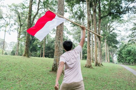 asian young man flapping Indonesian flagの写真素材