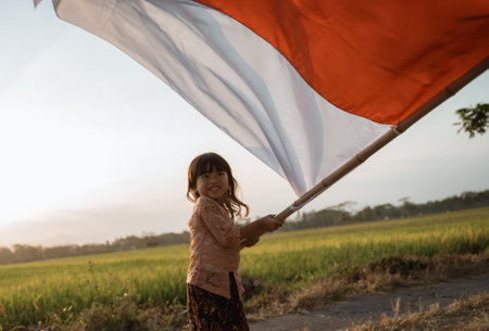 Little girl pride flapping Indonesian flag with happiness