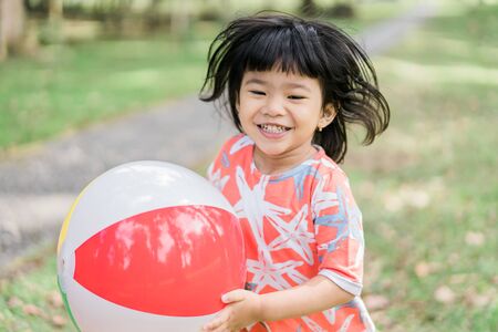 asian cute girl enjoy playing alone in the gardenの写真素材