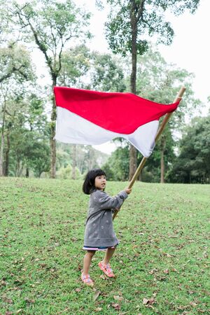 asian little girl flapping Indonesian flagの写真素材