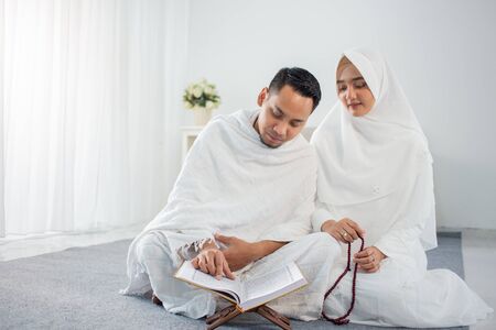 asian wife and husband praying with Al-Quran and tasbihの写真素材