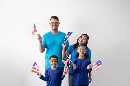malaysian family holding malaysia flag over white backgroundの写真素材