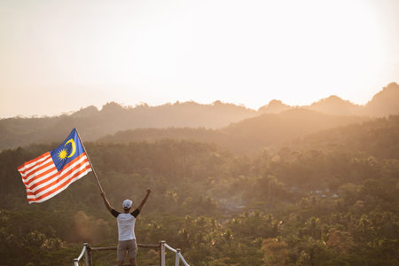 asian male with malaysian flag celebrating independence day