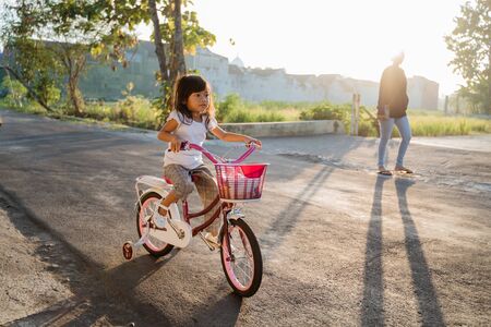 Toddler enjoy riding her bicycle outdoorの写真素材