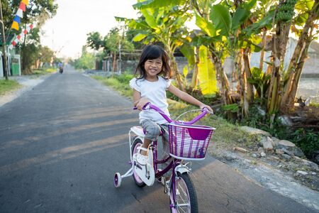 Toddler enjoy riding her bicycle outdoorの写真素材