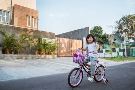 Toddler enjoy riding her bicycle outdoorの写真素材