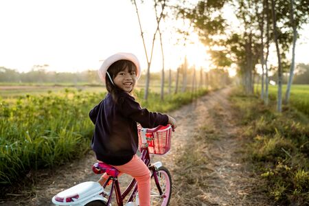 Toddler enjoy riding her bicycle outdoorの写真素材
