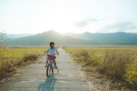 Toddler enjoy riding her bicycle outdoorの写真素材
