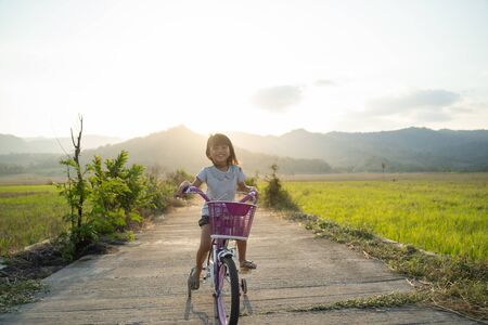Toddler enjoy riding her bicycle outdoorの写真素材