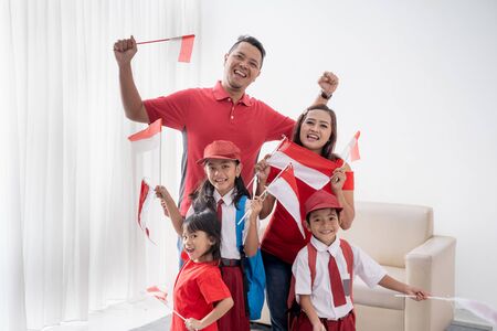Excited family with indonesian flag raise their armの写真素材