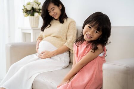 Asian little girl smiling when sit on sofaの写真素材