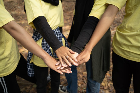 Happy volunteer stacking hands together