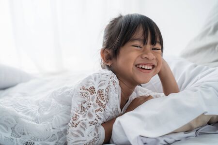 asian girl kid lying on bedの写真素材