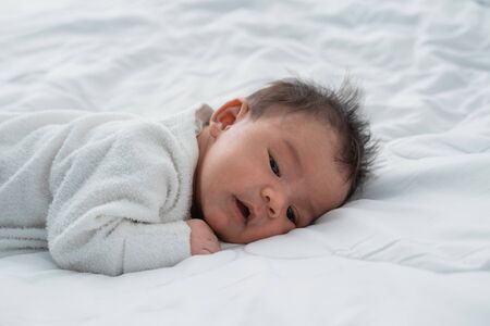 infant newborn baby on white bedの写真素材