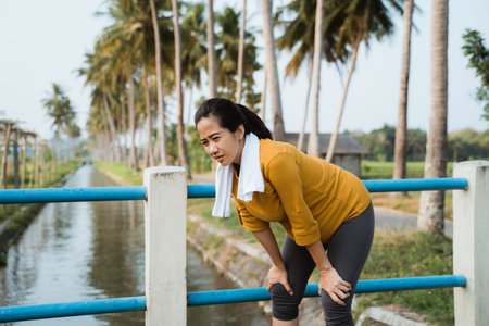 pregnant woman take a break after exercising outdoorの写真素材