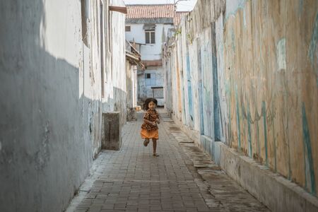 asian traditional girl javanese running in the alleywayの写真素材