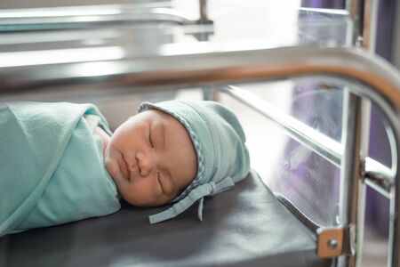 Newborn baby laying in cribの写真素材