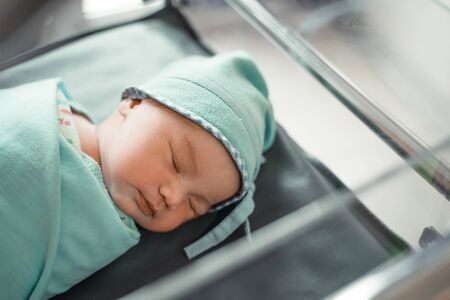 Asian newborn baby laying in cribの写真素材