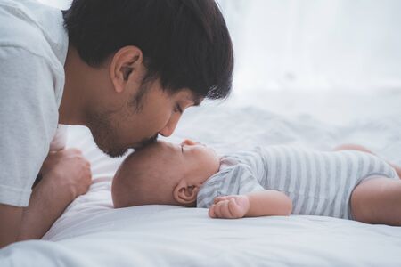 asian daddy kiss his baby boy on foreheadの写真素材