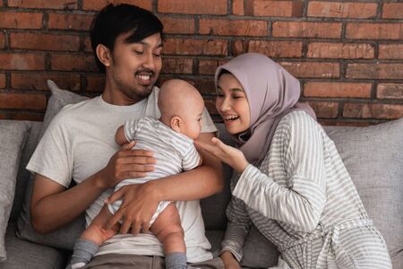muslim parent with their newborn baby enjoy time togetherの写真素材