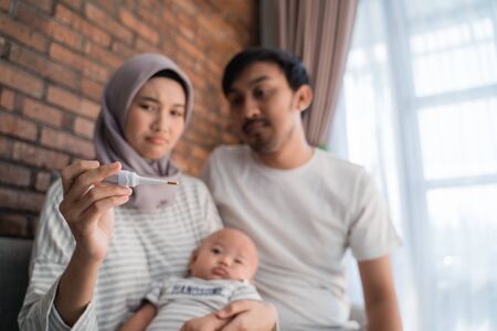 parent using thermometer to check their son conditionの写真素材