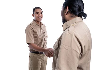 partner worker wearing uniform sealing a deal by shaking handの写真素材