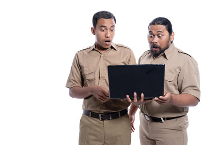 shocked and suprised worker while looking at laptop together