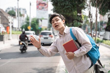 asian student waiting a transport in a hurryの写真素材