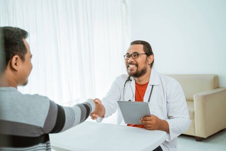 doctor and patient shake hand greeting in the clinicの写真素材