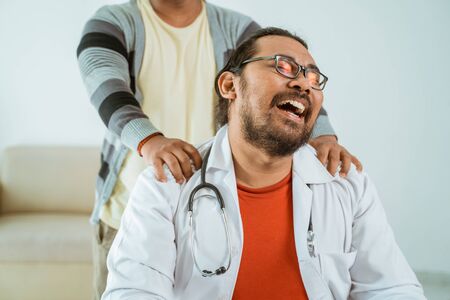 patient giving massage to his tired doctorの写真素材