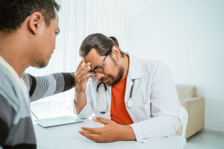 stress doctor and patient try to comfort him. depress doctor of work pressure in officeの写真素材