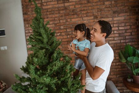 asian father and daughter installing christmas treeの写真素材